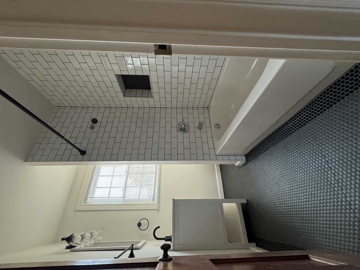 Remodeled bathroom with subway tile and penny tile accents