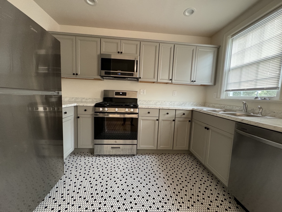 Updated kitchen with gray cabinets and marble countertops